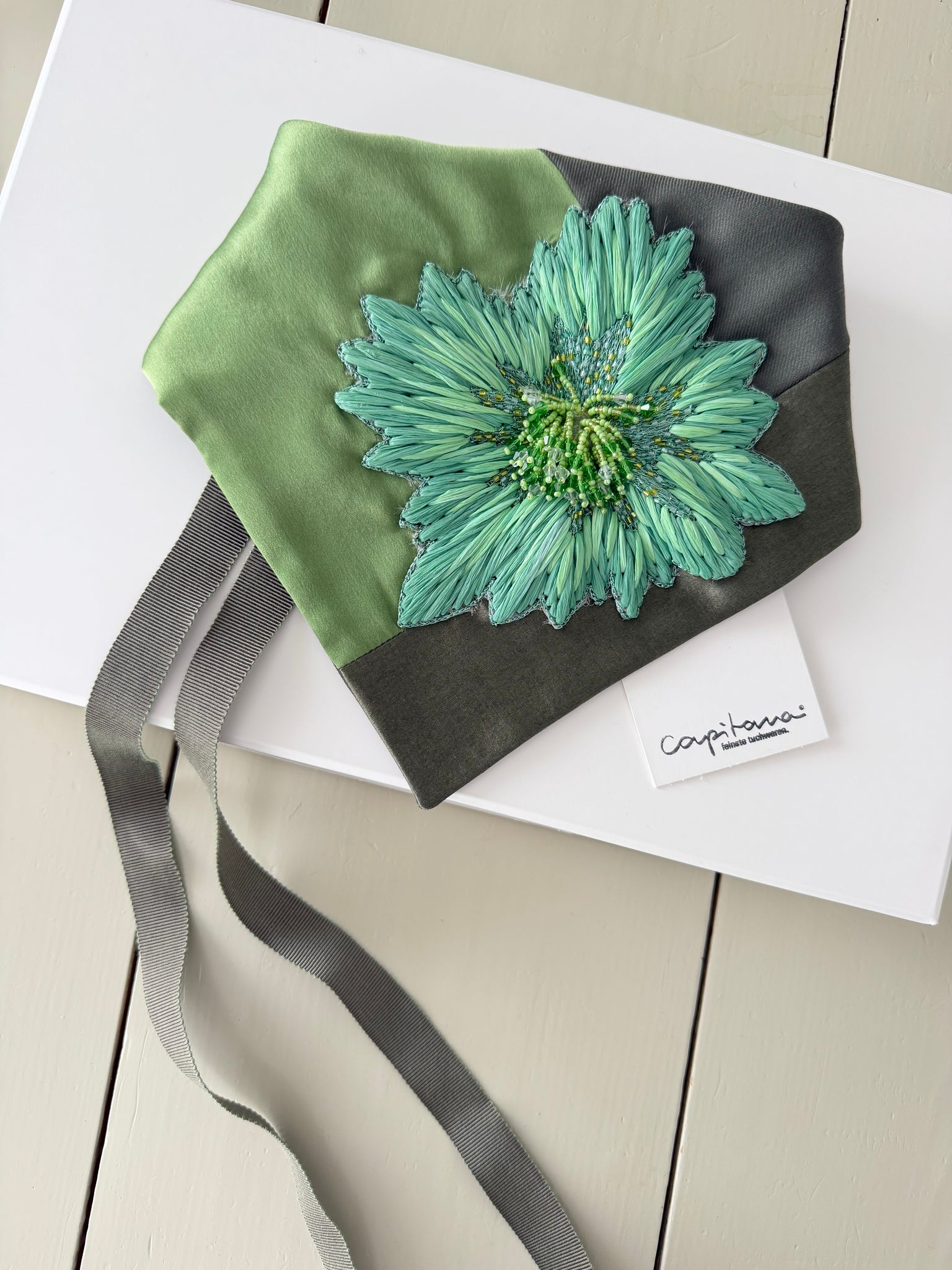 Capitana MONTI PICCOLO - kleines Dreieckstuch in grün mit handgestickter Blüte aus Raffiagarnen, Lurex und Perlenapplikationen, Seide und Wolle, limitierte Auflage, Atelier Frankfurt